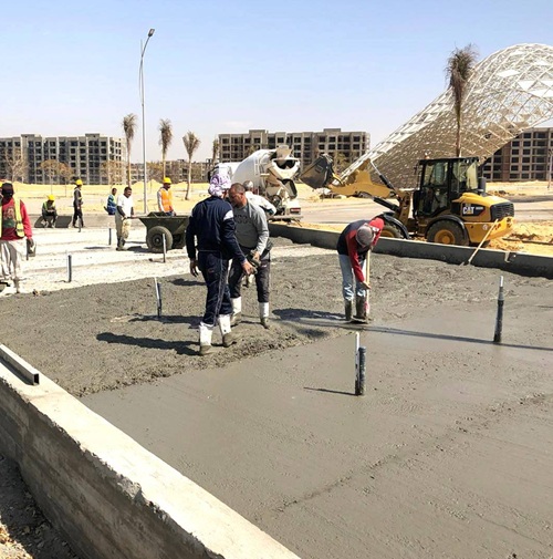 "Target Engineering team casting reinforced concrete flooring at Cairo Airport Garage, using laser screeds and power trowels for precision finishing. Workers in safety gear ensure durable, heavy-duty floors for industrial and commercial projects."