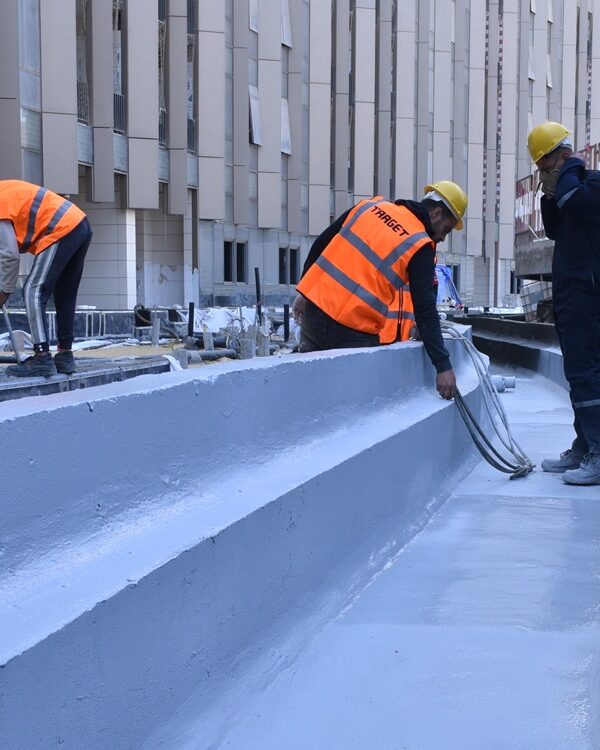 Hot applied polyurea being sprayed onto a roof surface
