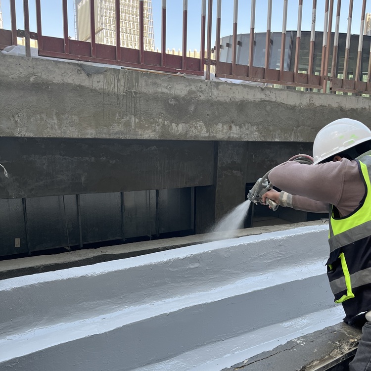 Hot applied polyurea being sprayed onto a roof surface
