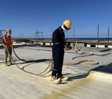 "Certified Technician Spraying Hot Applied Polyurethane Foam Insulation on an Egyptian Roof - Target for Industrial Services"