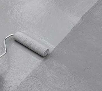 Applying an aliphatic topcoat by roller over a waterproofing membrane