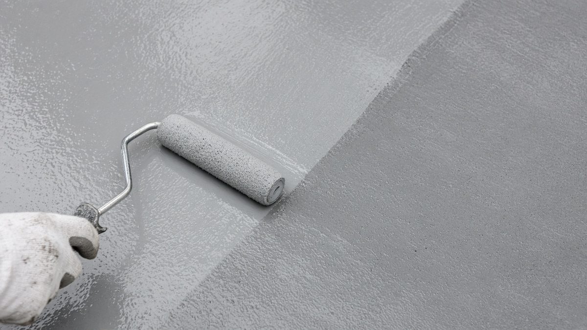 Applying an aliphatic topcoat by roller over a waterproofing membrane