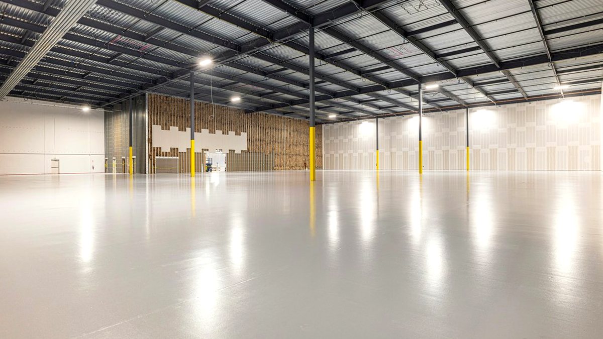 Smooth, glossy epoxy flooring across a large warehouse after installation