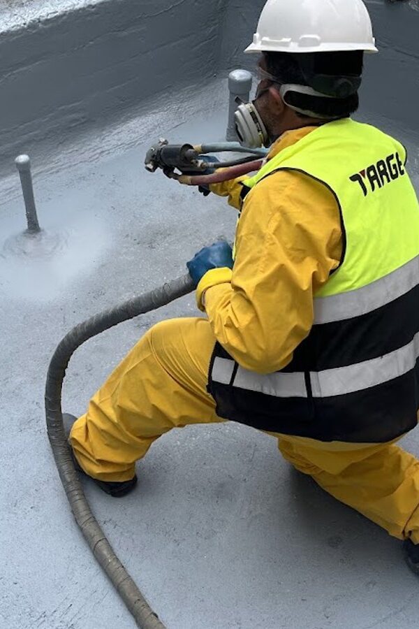 Target technician spraying polyurea inside a concrete fountain basin