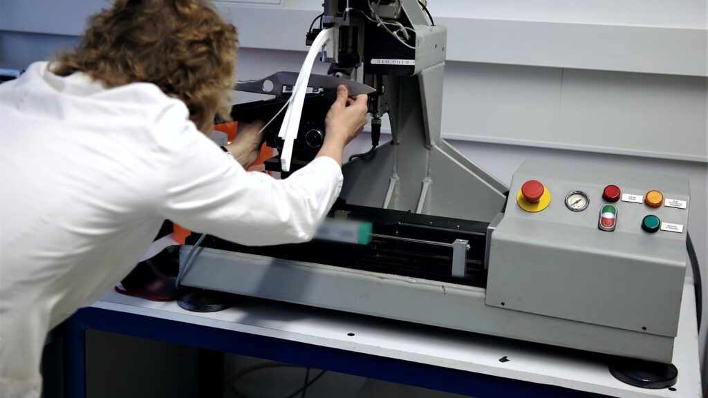 Polyurea certifications rest on lab tests like this: technician setting a sample in a material testing machine