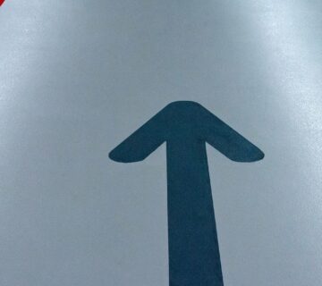Smooth coated car park floor with a direction arrow, the kind of finish a polyurea car park deck coating system aims for