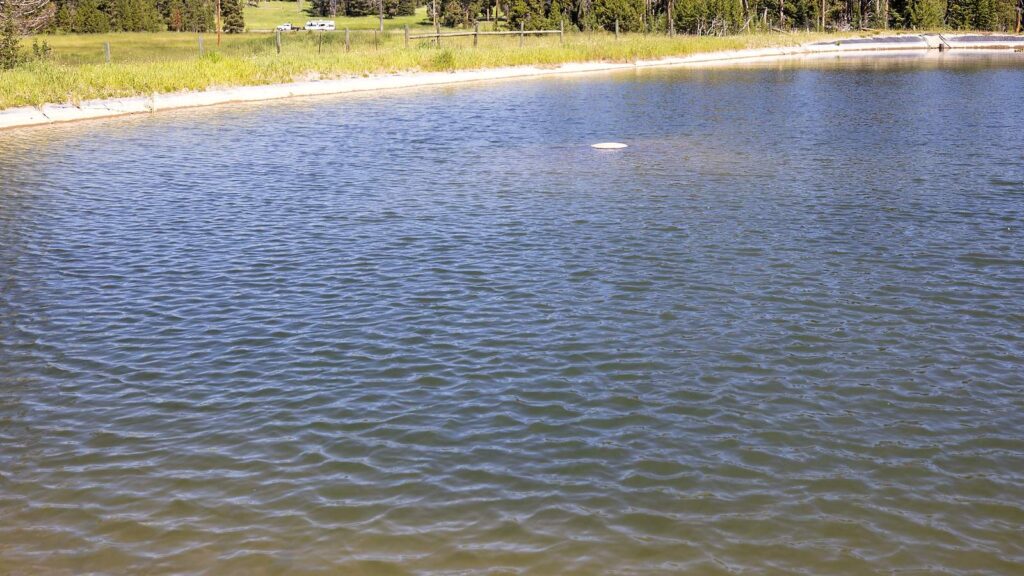 Filled, lined open water reservoir; the same edge and lining principles apply to polyurea pond lining