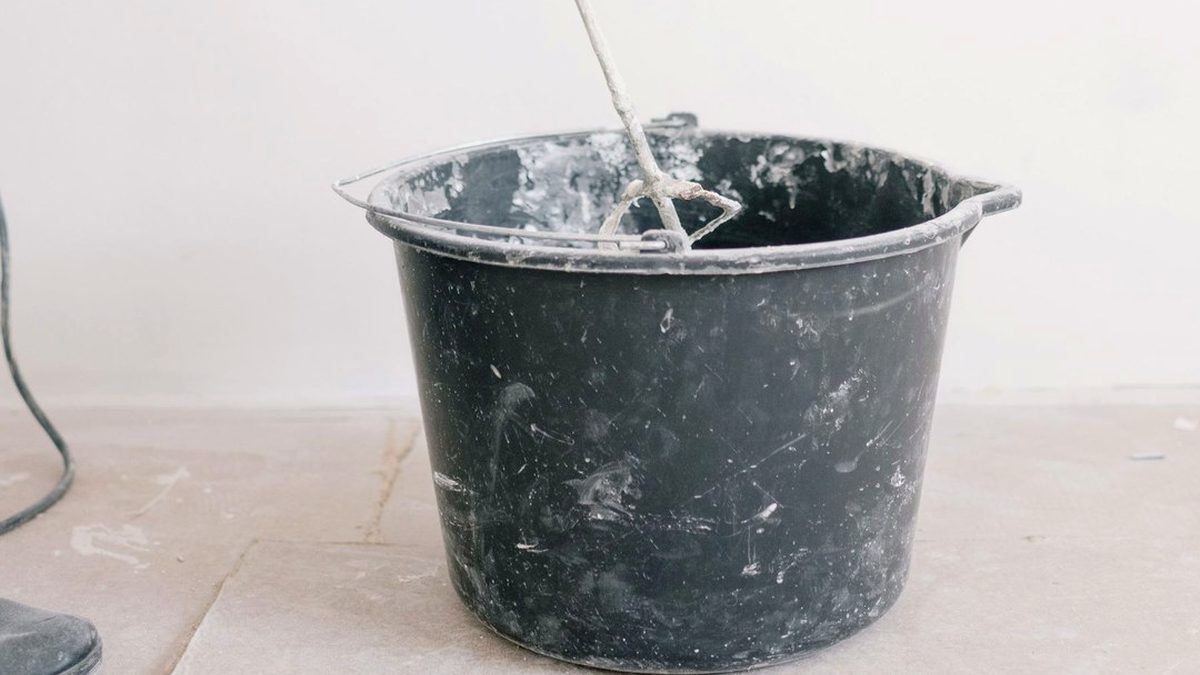 Mixing rigid cementitious waterproofing components in a bucket with a slow-speed drill paddle